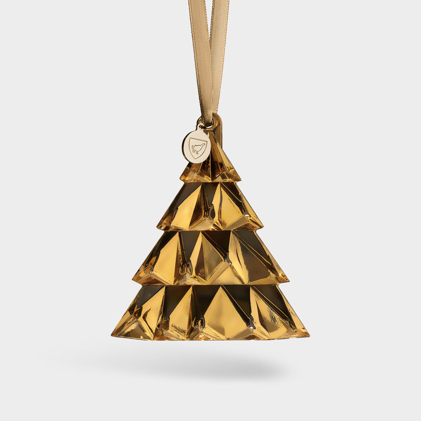 21K Gold Christmas tree ornament hanging from a gold ribbon with a gold tag featuring the Orrefors logo on a white background