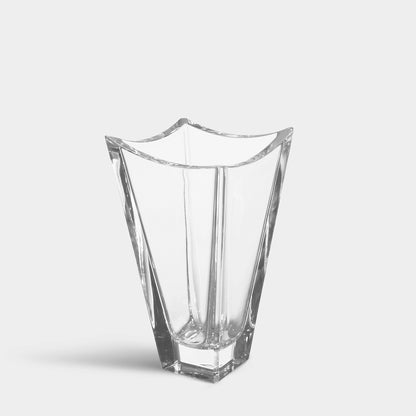 A clear glass Polaris vase with a geometric, faceted design and a wavy rim, shown on a light gray background.