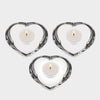 Three heart-shaped candle holders with candles on a white background