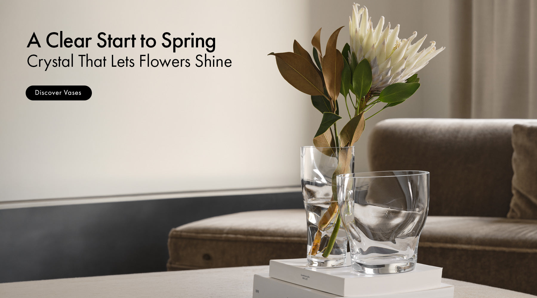 Clear crystal vase with flowers on a table in a living room setting