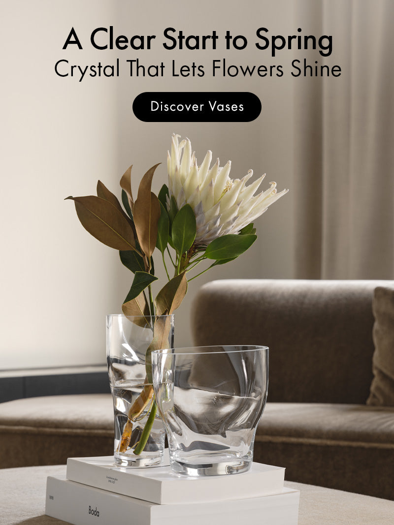 Clear glass vases with flowers on a table in a living room setting