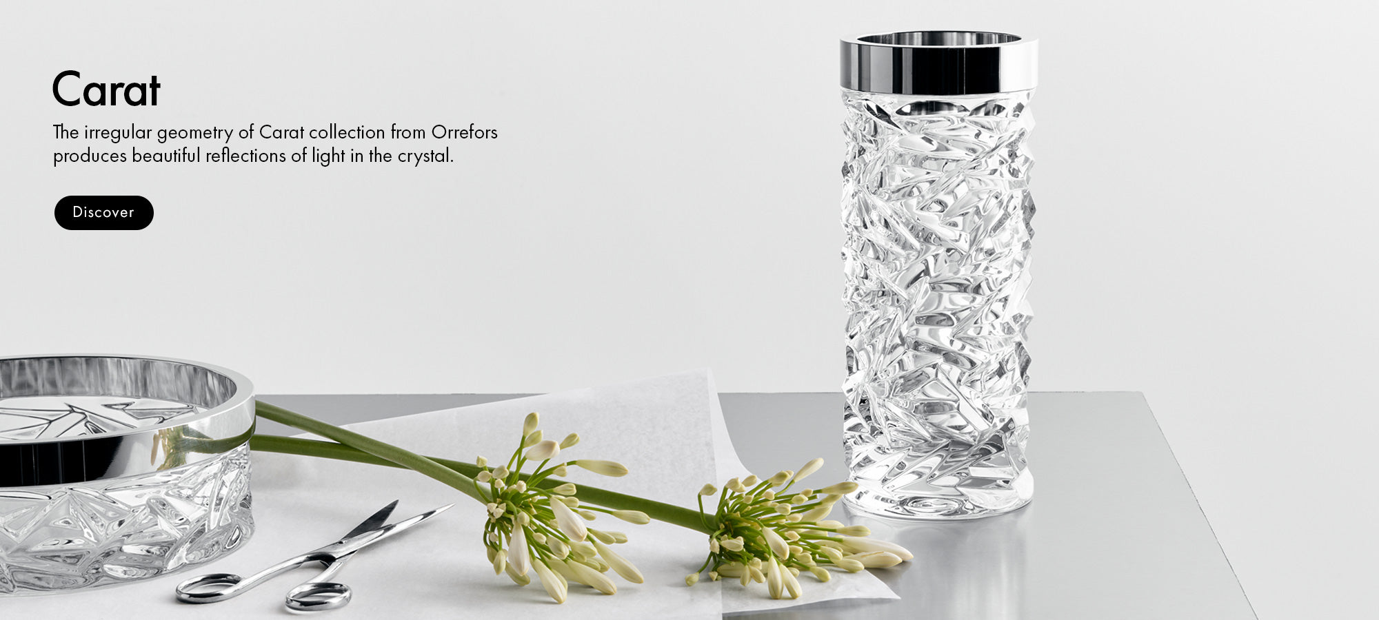 Carat collection crystal glass vase and bowl with floral arrangement on a white surface