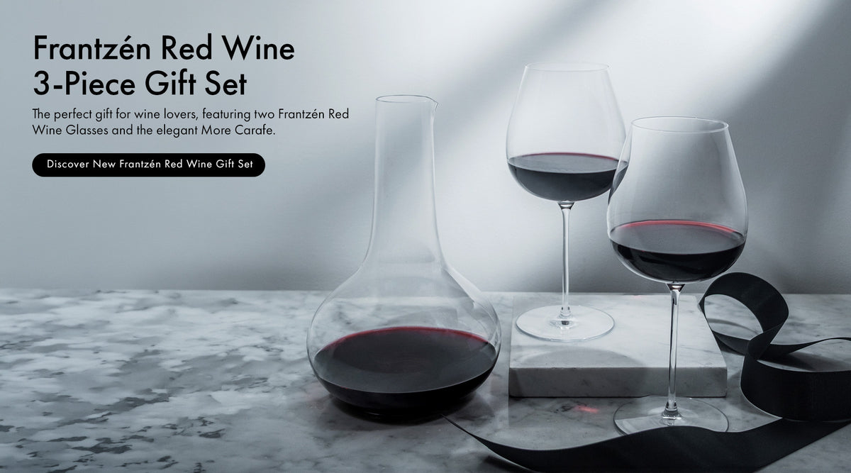 Frantzén Collection 3-Piece Gift Set featuring 2 Frantzén Red Wine Glasses and a More Carafe with a black gift wrapping ribbon on a marble surface with a light background and text describing the new Frantzén Red Wine 3-Piece Gift Set.