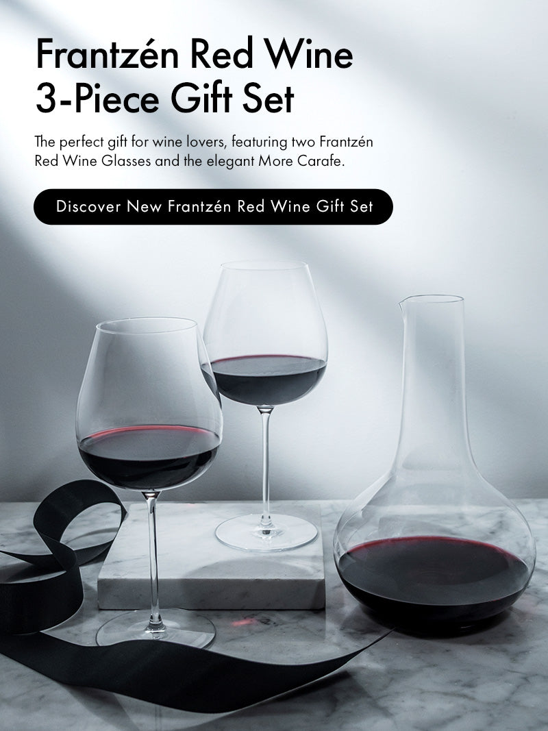 Frantzén Collection 3-Piece Gift Set featuring 2 Frantzén Red Wine Glasses and a More Carafe with a black gift wrapping ribbon on a marble surface with a light background and text describing the new Frantzén Red Wine 3-Piece Gift Set.