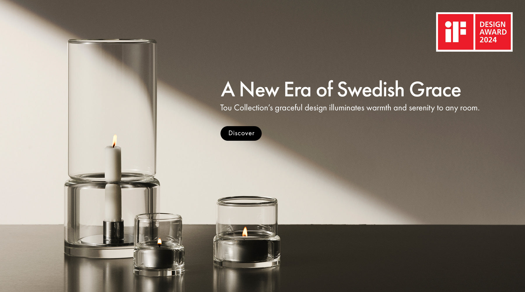 Tou collection of three clear glass candle holders with lit candles displayed on a dark reflective surface against a warm beige wall, with promotional text and an iF Design Award 2024 badge in the upper right.